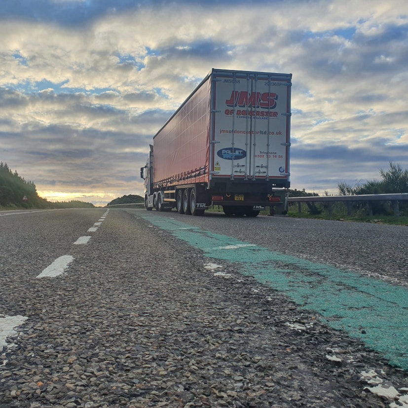 Truck driving on a long road